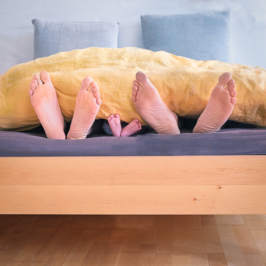 family of feet in bed